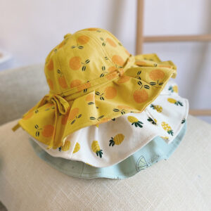 chapeaux pour bébé jaune blanc et bleu, sur une table en bois