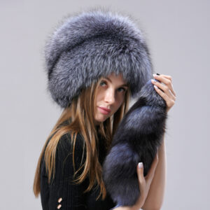 fille portant un bonnet russe gris en fausse fourrure avec une fausse queue de renard, sur fond gris
