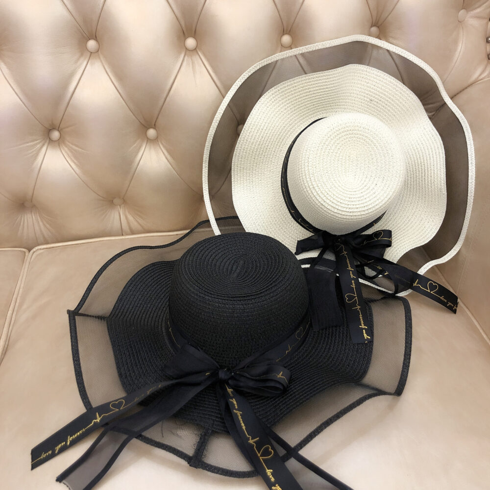 on voit posés sur un fauteuil deux chapeaux bretons en tulle et en paille de couleur noir et blanc