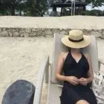 Canotier noir porté par une femme à la plage