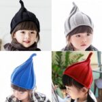 4 enfants portants des chapeaux pointus en coton et de couleurs différentes : noir, gris, bleu et rouge.