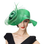 Femme portant un chapeau vert satiné avec une grosse fleur en organza. Chapeau catherinette