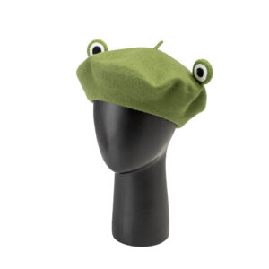 béret vert en feutre avec des yeux de grenouille posé sur une tête de mannequin en plastique noire