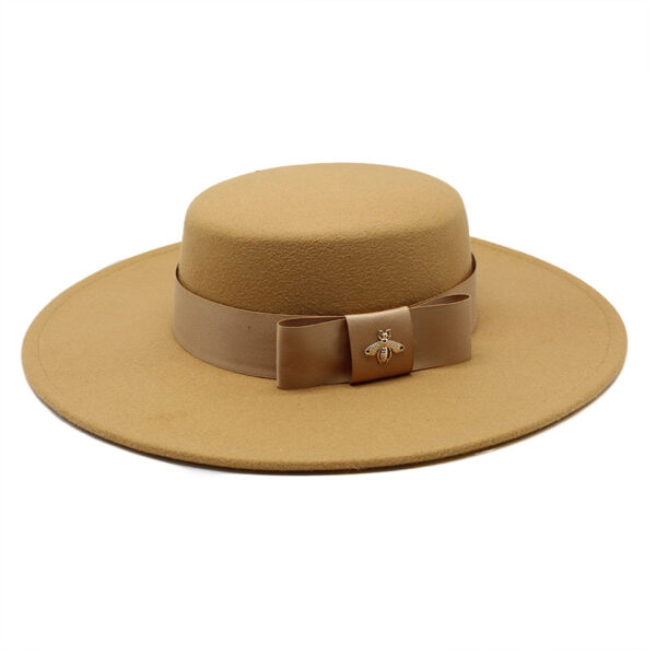 Un chapeau en feutrine marron avec un ruban noué autour sur fond blanc