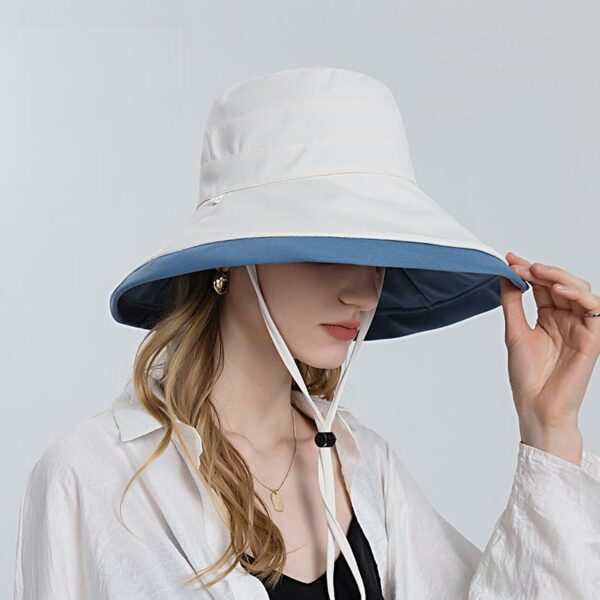 Chapeau anti UV double-face pour femmes blanc et bleu avec cordon de serrage porté par une mannequin