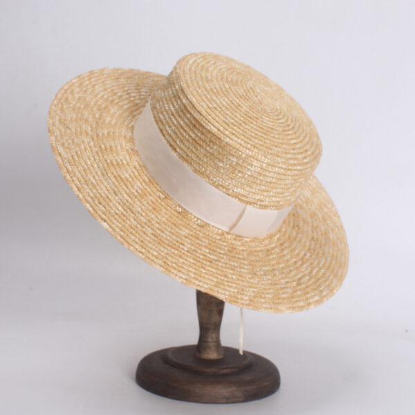 Un chapeau de paille avec ruban posé sur un socle en bois