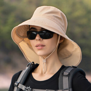 Chapeau anti UV beige pour femmes, avec cordon de serrage porté par une mannequin avec lunette de soleil