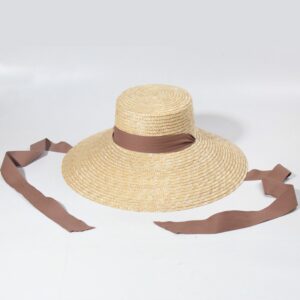 un chapeau de paille avec ruban marron sur fond blanc.