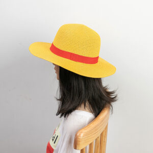 Chapeau en paille, style Luffy pour femmes, de couleur jaune avec un ruban rouge, porté par une mannequin assise sur une chaise de dos