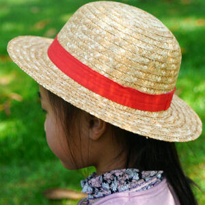 Chapeau en paille beige avec ruban rouge, style Luffy pour enfants, porté par une petite fille de dos