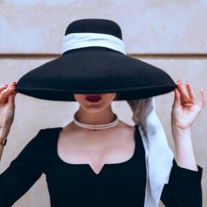 Chapeau capeline avec ruban blanc porté par une femme