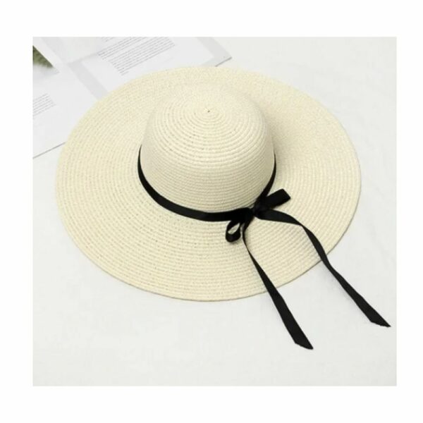 on voit sur un fond gris clair un chapeau de paille avec un ruban noir pour femme