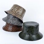 on voit sur un fond blanc 4 chapeaux de pluie réversibles à imprimé léopard pour femme, ils sont de couleurs différentes