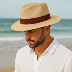 Homme portant un chapeau Panama en paille avec ruban contrasté marron, à la plage.