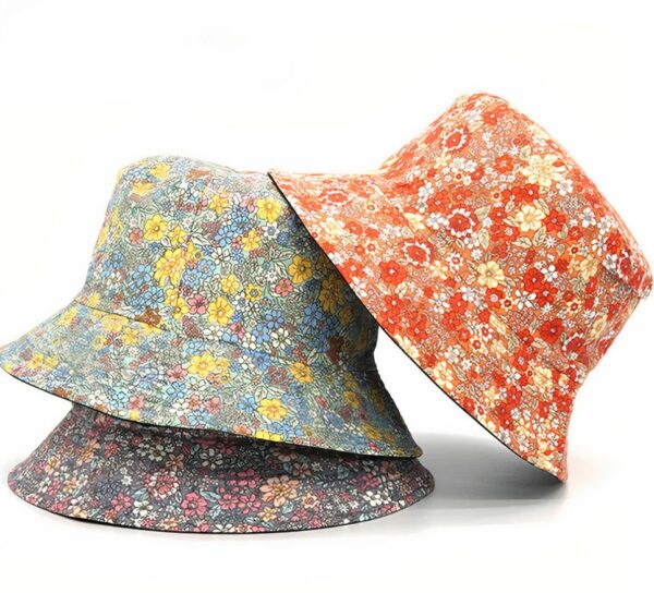 3 chapeaux bob fleuris style liberty, sur fond blanc. Il yen a un mauve, un bleu et un rouge orangé.