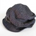 Un chapeau femme visière courte vintage denim en tissu jean foncé, posé sur fond blanc.